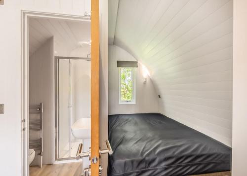 1 dormitorio pequeño con 1 cama en una habitación con ventana en Hillcroft Park Glamping, en Pooley Bridge
