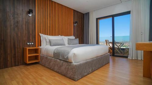 a bedroom with a large bed and a balcony at Razane Hôtel in Kenitra