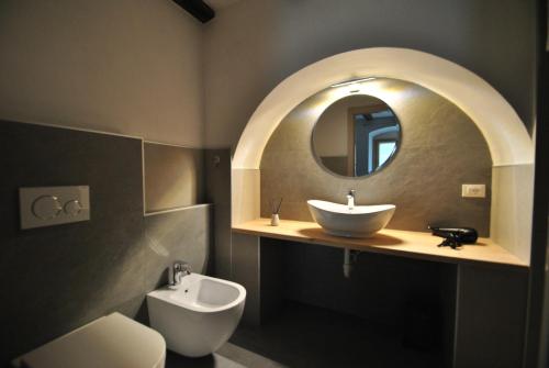 a bathroom with a sink and a toilet and a mirror at B&B alla Pieve in Calceranica al Lago