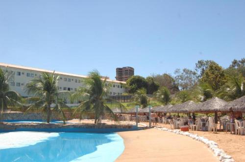 a pool at a resort with chairs and umbrellas at Verdes Vales Lazer Hotel in Juazeiro do Norte