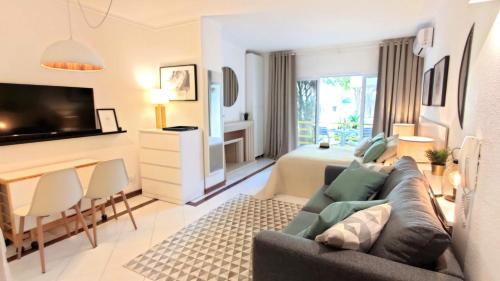 a living room with a couch and a bedroom at Al-Charb Studio in Quarteira
