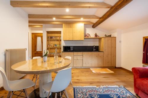 a kitchen and living room with a table and chairs at Baita La Cascata in Isolaccia