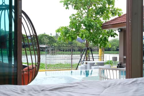 a bedroom with a view of a swimming pool at บ้านบางเตยริมน้ำพูลวิลล่า in Ban Bang Rathuk