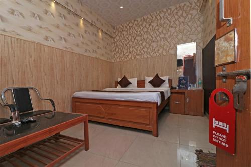 ein Schlafzimmer mit einem Bett und einem Schreibtisch in einem Zimmer in der Unterkunft OYO 13234 Hotel Mahak in Bijnaur