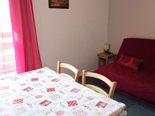 Cette chambre comprend une table et un lit avec une couverture. dans l'établissement Studio cabine 4 pers pied des pistes, Les Adrets-Prapoutel - FR-1-557-39, à Les Adrets