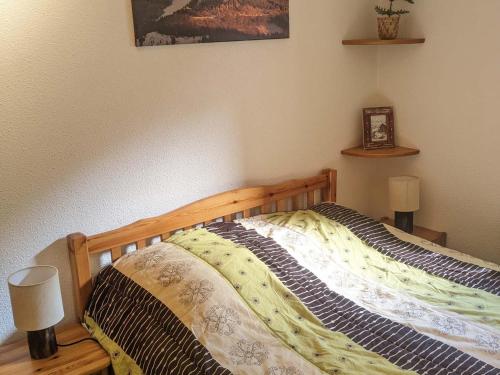 ein Schlafzimmer mit einem Bett mit einem Holzrahmen in der Unterkunft Appartement Les Adrets-Prapoutel, 2 pièces, 6 personnes - FR-1-557-78 in Les Adrets