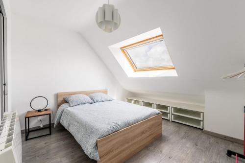 a bedroom with a bed and a skylight at Gite Ti Coz piscine intérieure in Caden