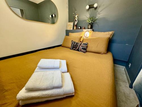 1 dormitorio con 1 cama grande con almohadas y espejo en Le Poète - Appartement Confort - Parking Privé - WIFI, en Gradignan