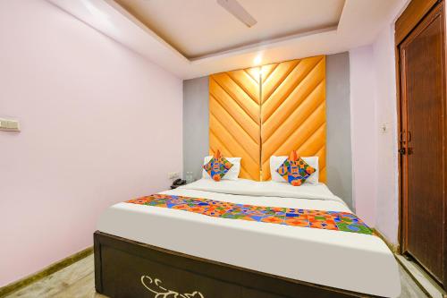 a bedroom with a large bed with a wooden headboard at FabHotel Iris Lite in New Delhi