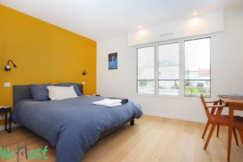 une chambre avec un lit, une table et des fenêtres dans l'établissement PINCE [*Ty Bleuniou * ]- Proche mer et cœur de ville, à Pornichet