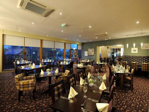 uma sala de jantar com mesas e cadeiras num restaurante em The Strathearn Hotel em Fife