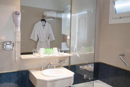 uma casa de banho com um lavatório e uma cabina de duche em vidro. em Hotel Presidente Buenos Aires em Buenos Aires