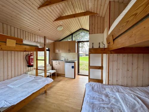 a room with two bunk beds and a kitchen at Arhus Cottage and Camping in Hella