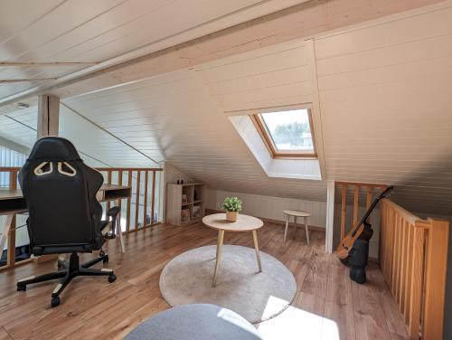 Zimmer im Dachgeschoss mit einem Schreibtisch, einem Stuhl und einer Gitarre in der Unterkunft Lovely home by Glomma river! in Vidnes