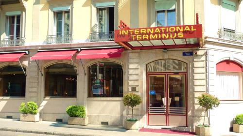un restaurante con un letrero rojo en un edificio en Hotel International & Terminus, en Ginebra