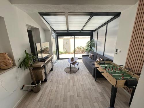 - un salon avec un baby-foot et un canapé dans l'établissement L'Alyscamps Appartement Arles, à Arles