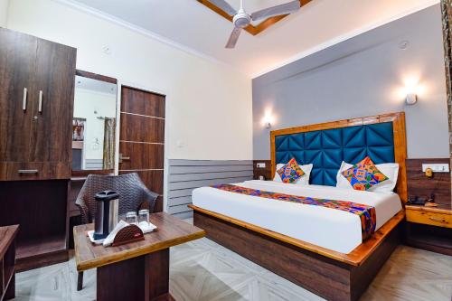 a bedroom with a large bed and a desk and a chair at FabHotel KK Residency in Mājra