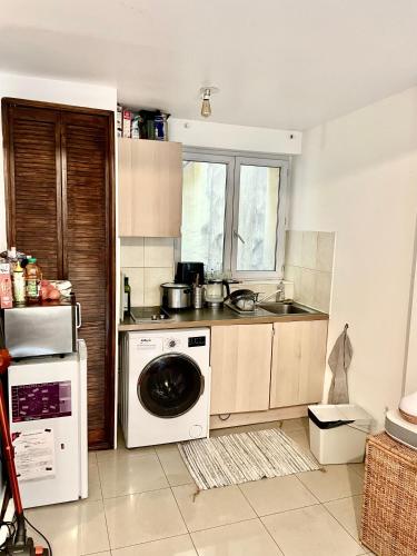 une cuisine avec une machine à laver et un évier dans l'établissement Nid douillet parisien, à Paris