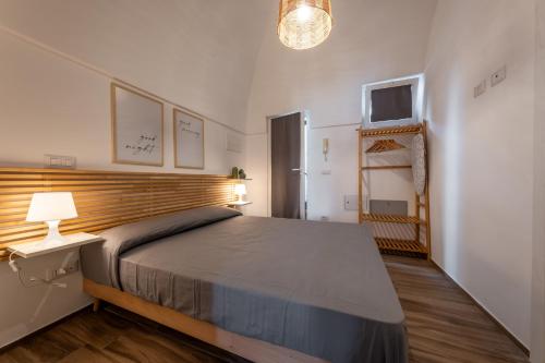 ein Schlafzimmer mit einem Bett und einem Fernseher an der Wand in der Unterkunft Dimore Calculli - Puglia Mia Apartments in Monopoli