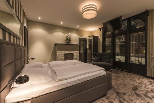 a bedroom with a large bed and a fireplace at Hotel-Restaurant Unicum Elzenhagen in Poeldijk