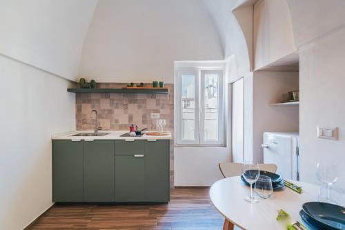 eine Küche mit Spüle und einem Tisch in der Unterkunft Dimore Calculli - Puglia Mia Apartments in Monopoli