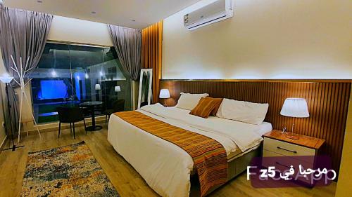 um quarto de hotel com uma cama grande e uma janela em شاليهات z5 الفندقية em Al ‘Awājīyah