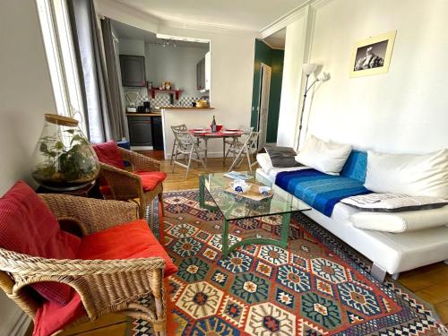 un salon avec un canapé et une table dans l'établissement L'appartement Jean Moulin, à Paris