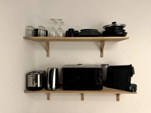 une étagère en bois avec des appareils sur un mur dans l'établissement Studio Ceineray 2pers, à Nantes