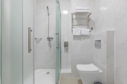 Green Line Hotel في كييف: حمام أبيض مع دش ومرحاض