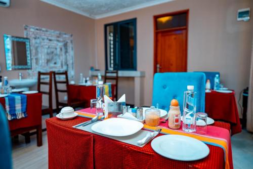 uma mesa com uma toalha de mesa vermelha e pratos sobre ela em MLIMWA HILL PALACE em Dodoma