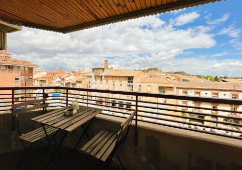 una mesa y sillas en un balcón con vistas en Pensión las Hojas en Tudela