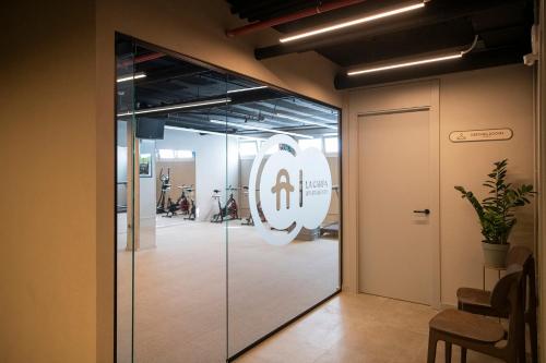 a glass door leading into a room with a gym at APARTAMENTS LA CARPA in Banyoles