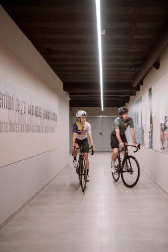 two men riding bikes down a hallway in a museum at APARTAMENTS LA CARPA in Banyoles