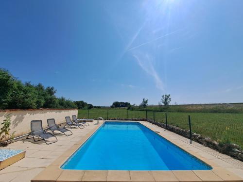 - une piscine avec des chaises longues à côté d'un champ dans l'établissement Private Villa with pool France - Villa Hirondelles, à Saint-Pierre-de-Juillers