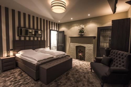 a bedroom with a bed and a chair and a fireplace at Hotel-Restaurant Unicum Elzenhagen in Poeldijk