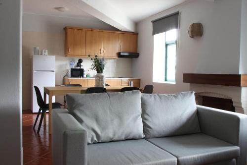 uma sala de estar com um sofá e uma cozinha em Casas do Monte em Palmela