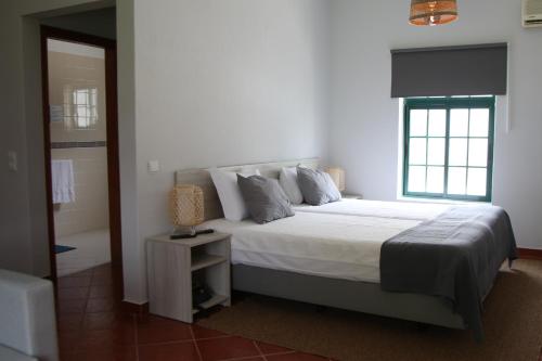帕爾梅拉的住宿－Casas do Monte，一间卧室设有一张大床和一个窗户。