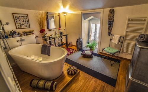 ein Bad mit einer großen Badewanne in einem Zimmer in der Unterkunft Manoir de la Peylouse in Saint-Venant