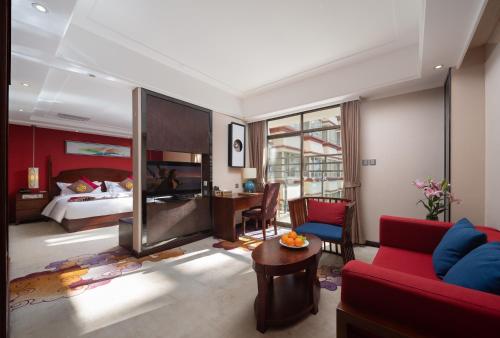 a living room with a red couch and a bed at 香格里拉蜀锦沐云酒店 in Shangri-La