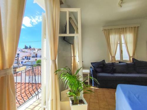 a living room with a couch and a window at Grandma’s House - Το σπίτι της Γιαγιάς in Skiathos Town