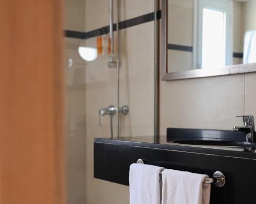 y baño con lavabo, espejo y toallas. en Hoposa Pollensamar Apartamentos, en Puerto Pollensa