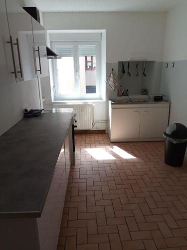 une cuisine avec un comptoir et une fenêtre. dans l'établissement Maison de campagne, à Thiaucourt