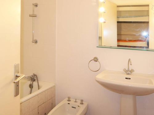 une salle de bain blanche avec un lavabo et un miroir dans l'établissement Appartement cosy pour 6 pers, proche centre, skis aux pieds - FR-1-322-225, aux Orres
