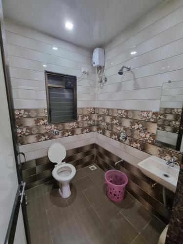 a bathroom with a toilet and a sink at The Living Space in Lonavala