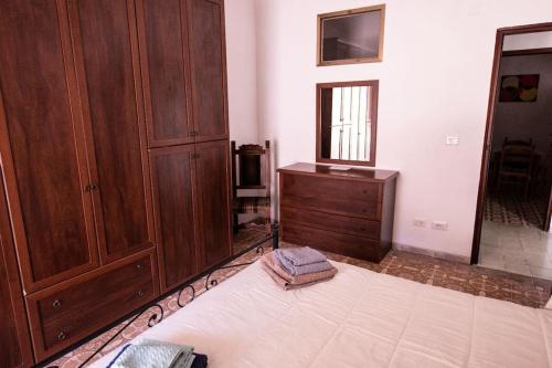 a bedroom with a large bed and a wooden cabinet at il Ciclope di Annalisa in Alatri