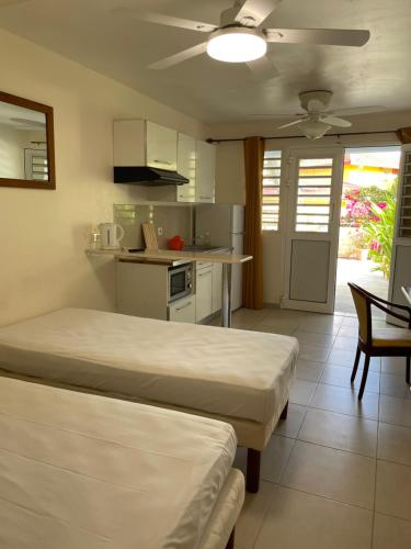 a room with two beds and a kitchen at Hôtel DOUCE VAGUE in Sainte-Luce