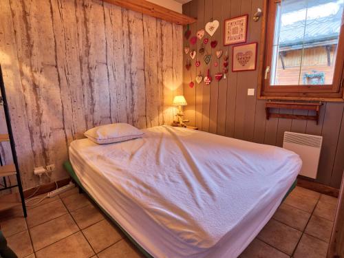 um quarto com uma cama numa parede de madeira em Appartement Notre-Dame-de-Bellecombe, 2 pièces, 4 personnes - FR-1-505-5 em Notre-Dame-de-Bellecombe