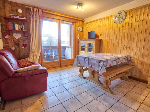 un salon avec une table et un canapé dans l'établissement Appartement cosy 4 pers au pied des pistes avec Wifi et Parking, animaux acceptés - FR-1-505-5, à Notre-Dame-de-Bellecombe