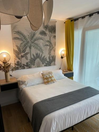 a bedroom with a large bed with two lamps at FACE À LA PLAGE Terrasse-Parking-Wifi-Draps et Serviettes in Hendaye