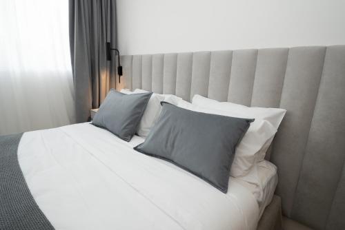 a large white bed with two pillows on it at Vain Boutique Hotel in Buenos Aires